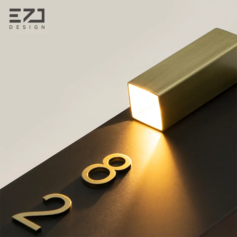 Close view of the top accent light on a black hotel door sign